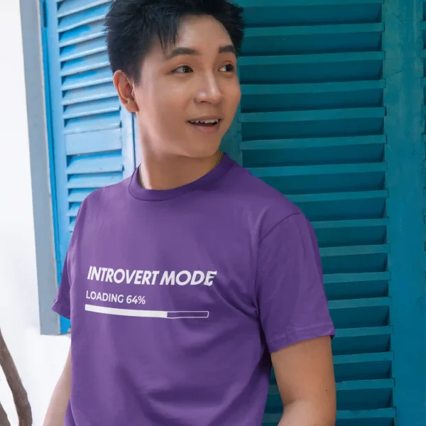 Young man wearing a royal purple Bella-Canvas t-shirt with white Introvert Mode print