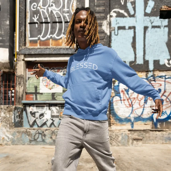 Young man wearing cornflower blue Just Hoods hoodie with white Blessed print