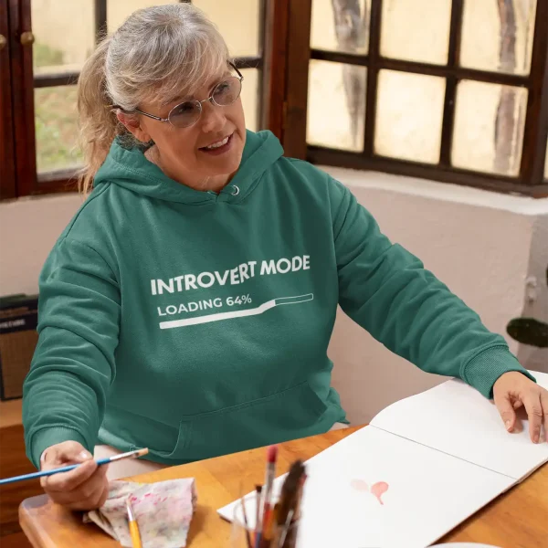 Woman wearing a moss green Just Hoods hoodie with white Introvert Mode print