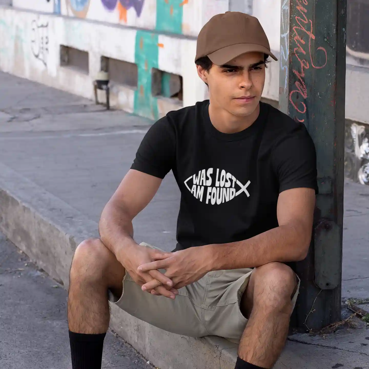 Man wearing a black Bella-Canvas t-shirt with white Found print