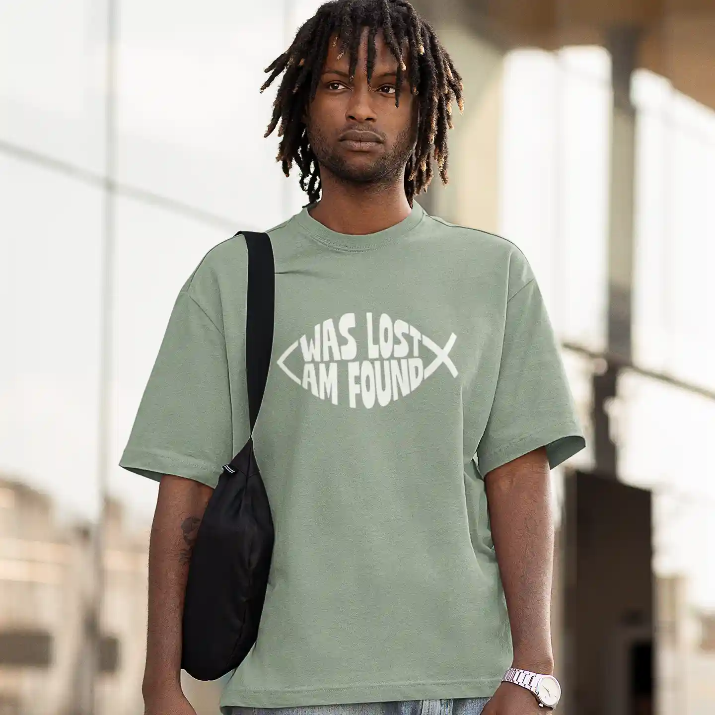 Man wearing a sage green Bella-Canvas t-shirt with white Found print