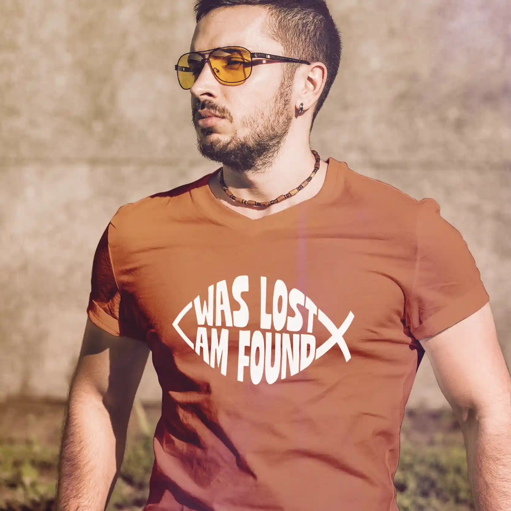 Man wearing a terracotta Bella-Canvas t-shirt with white Found print