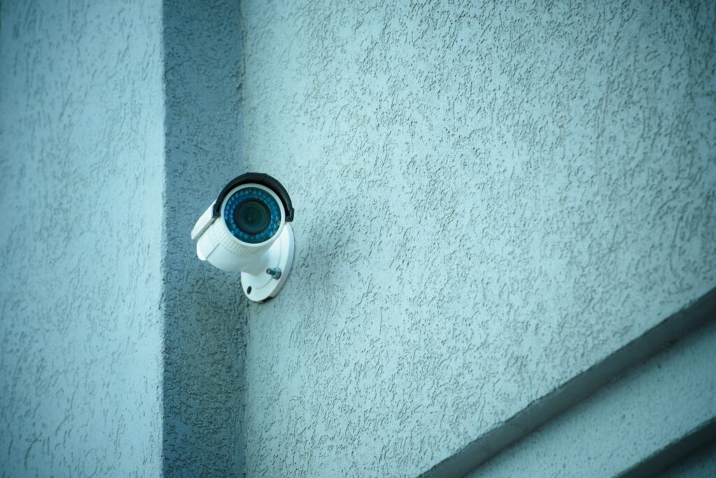 close up view of security camera on gray building facade