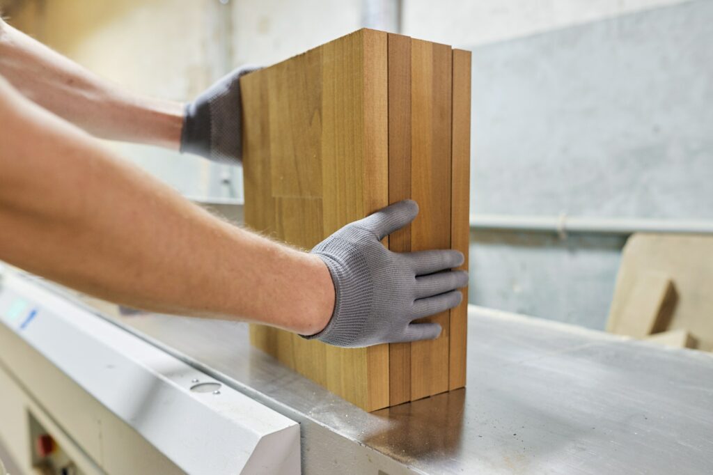 Wooden details in hands of male carpenter, woodworking industry