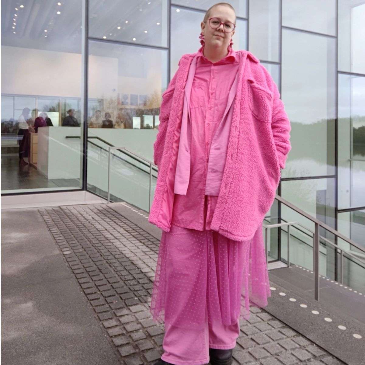 Elizabet står framför en byggnad på Konstnärligt campus, Umeå