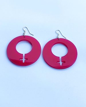 Stora lila örhängen i akryl med utskuret kvinnotecken i mitten av slow fashion-företaget Skamlös Design