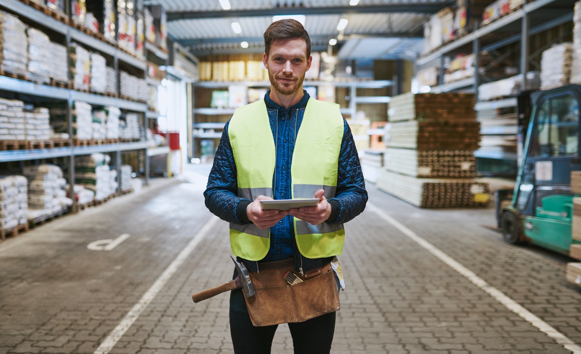 Young handyman or builder in a warehouse