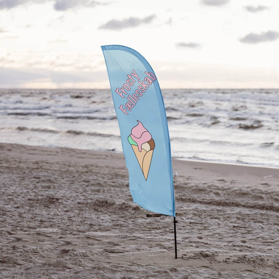 Beachflag på stranden med havet som baggrund