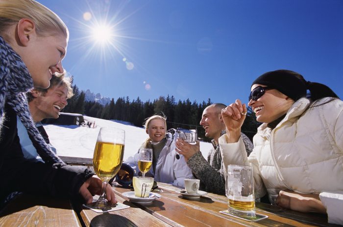 Friends Enjoying a Drink at a Table at a Ski Resort Michelangelo Gratton