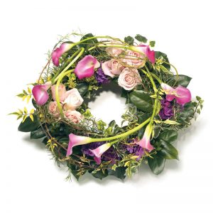 Begravningskrans ur Euroflorists sortiment av begravningsblommor; med kallor, rosor, hortensia och gröna blad.