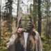 woman standing at woods holding green plant