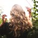 blonde haired woman standing between green plants