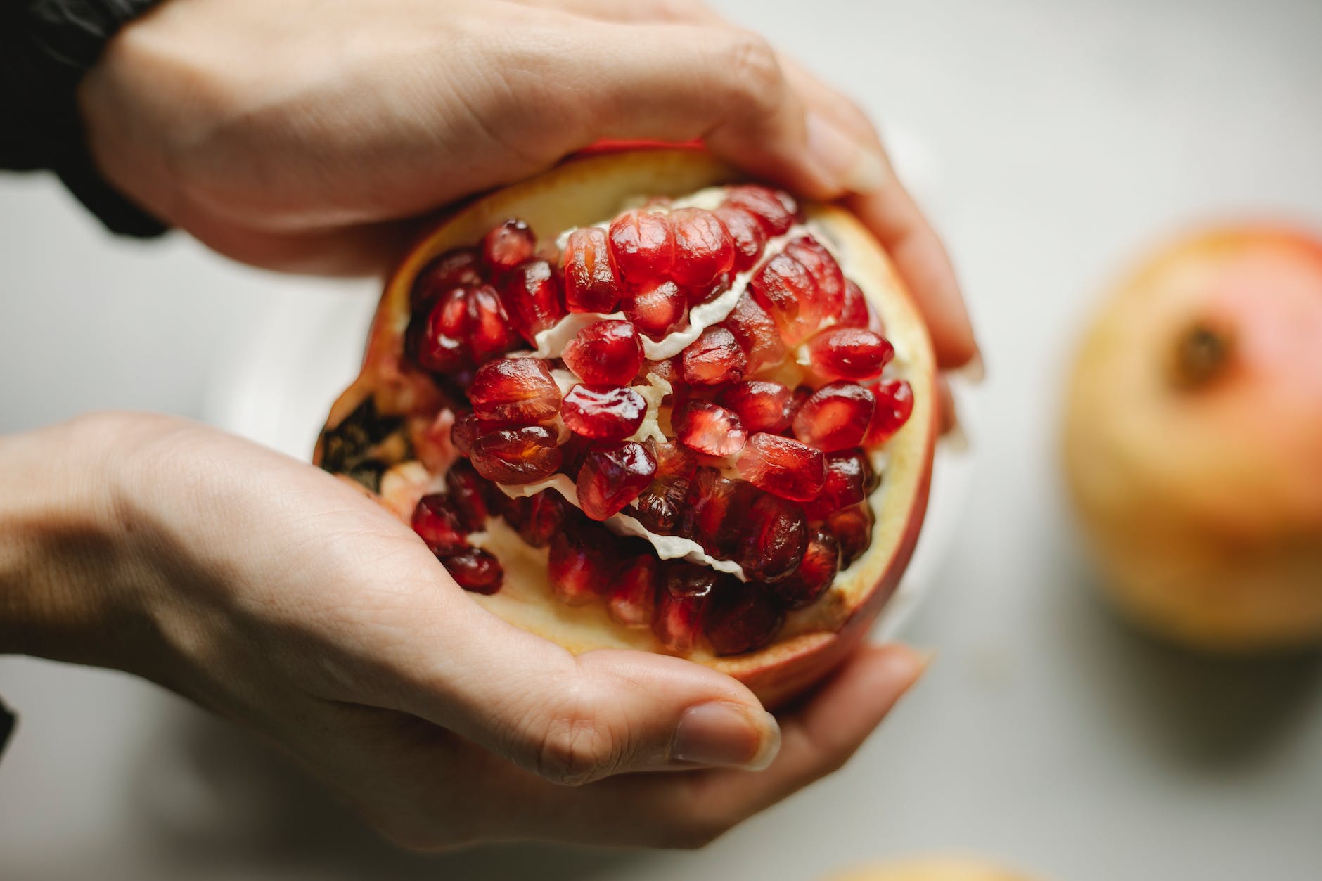 fresh pomegranate in hands of woman