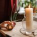 crop fortune teller near shiny candles at table at home