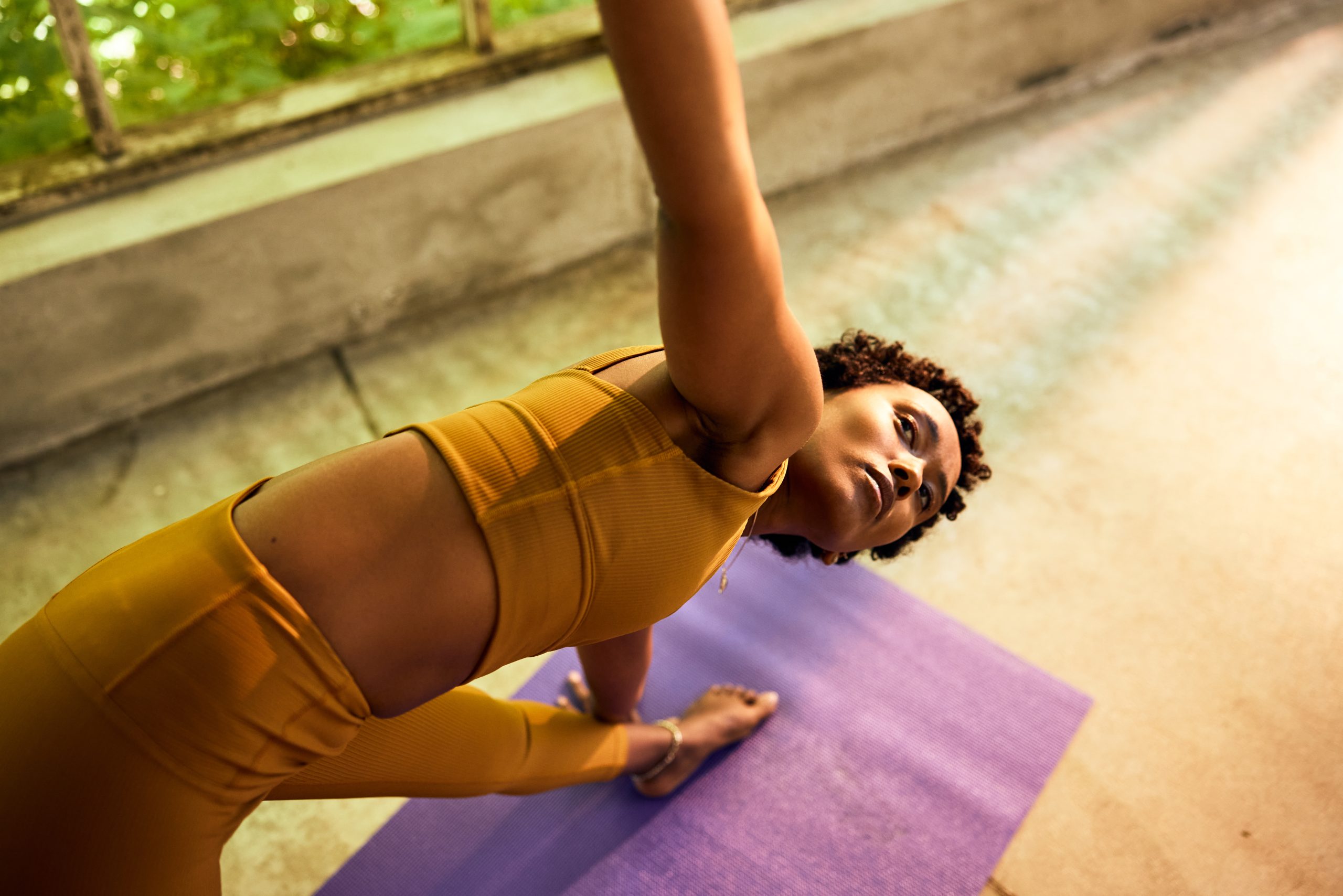 Fit young woman practicing yoga on a mat in a bright studio