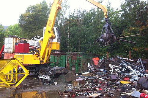 Bilde av en gravemaskin som flytter skrot - Brunæs Gjenvinning AS - Containerutleie og Avfallshåndtering, Sande i Vestfold