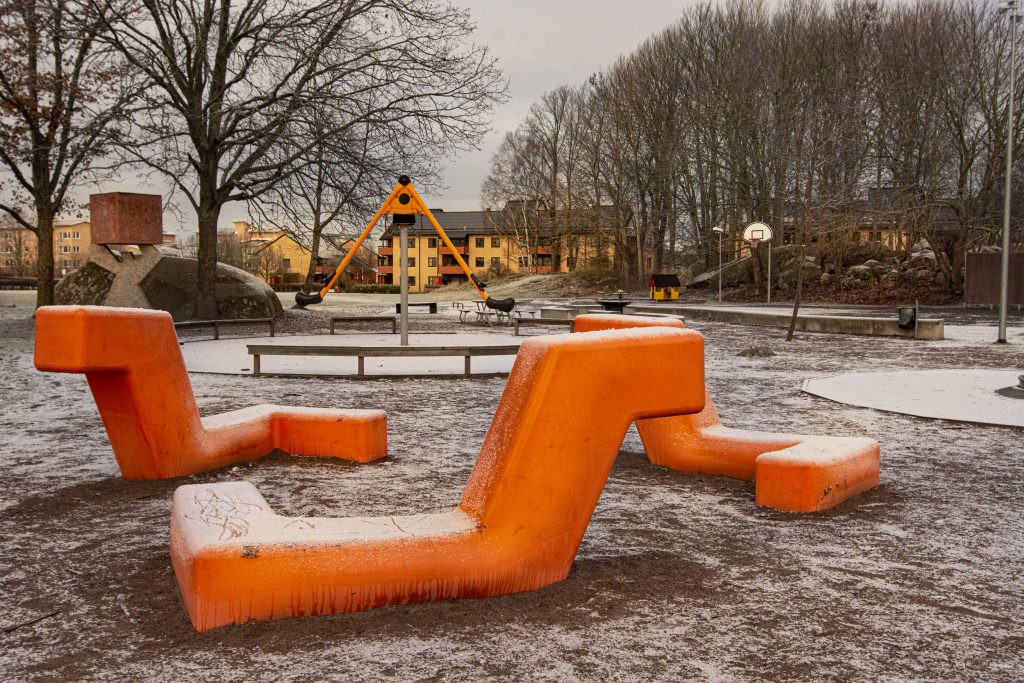 Orangea bänkar på en lekplats.