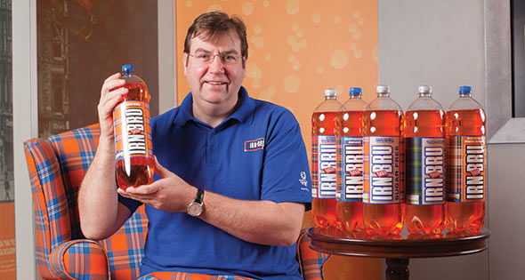 Kilted man holding bottle of Irn Bru