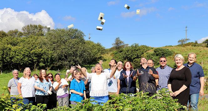 Crowd throwing boxes in air