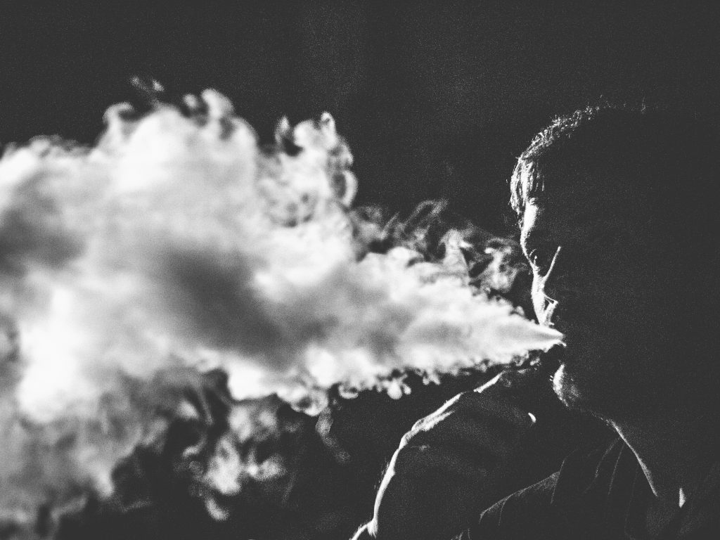 Black and white photo of man vaping