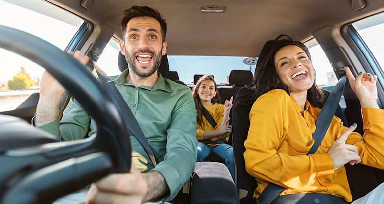 Family hand-jiving in a motor car