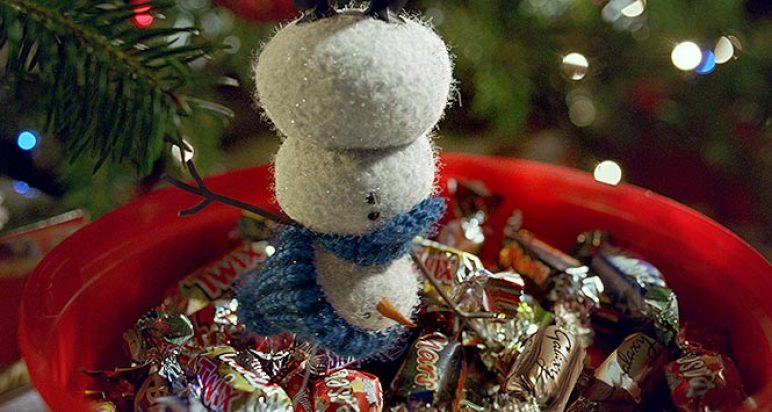 Snowman dangling over tub of Celebrations