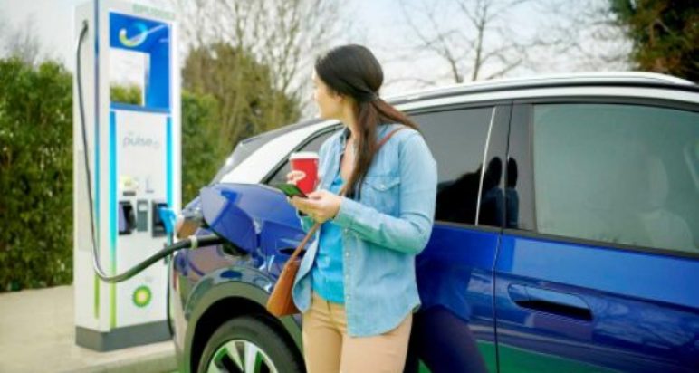 Image of a lady waiting for her EV to charge on bp pulse kit