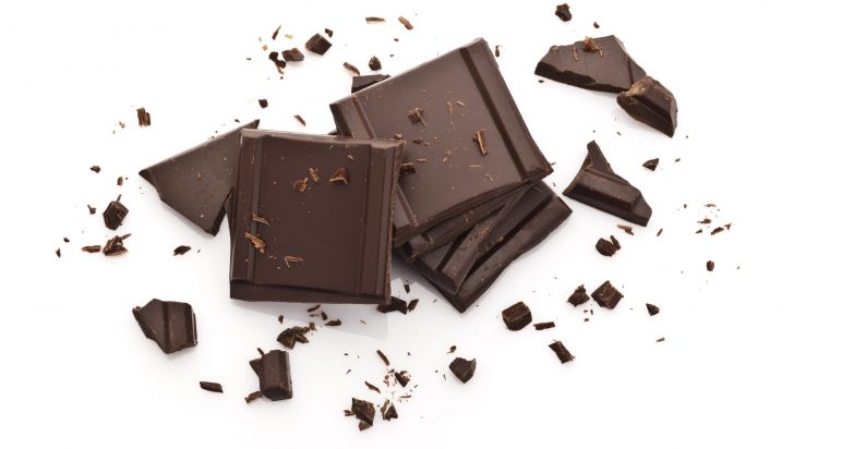 Top view of chocolate pieces with chocolate shavings isolated on white background. Predominant color are brown and white. DSRL high key studio photo taken with Canon EOS 5D Mk II and Canon EF 100mm f/2.8L Macro IS USM