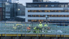 Jobbare på Hisingsbron. I bakgrunden syns en kontorsfastighet och i fönstren har man pyntat med ljusstakar.