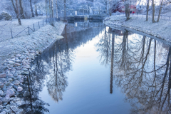 Skorstenen från fabriken syns i vattendraget.