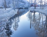 Skorstenen från fabriken syns i vattendraget.