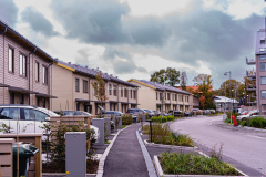 På baksidan av Nya Öjersjövägen, har radhusen som syns från vägen sina huvudingångar. Här är bilar parkerade vid varje radhus. Bilden är tagen mitt på dagen, så jag funderar på om alla är hemma eller åker man på annat sätt till sina arbeten?