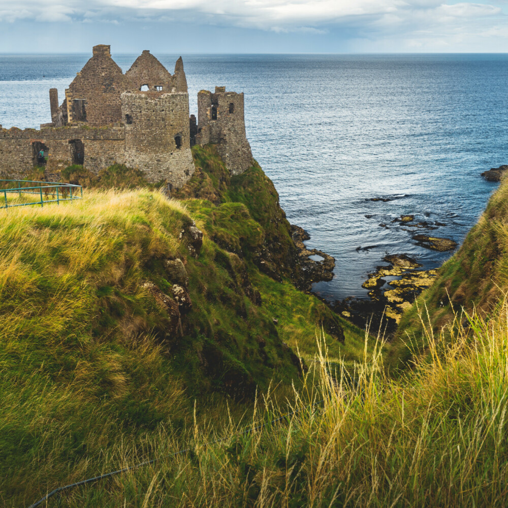 Dunluce castle on the cliff. Irish shoreline. Taxi Tours