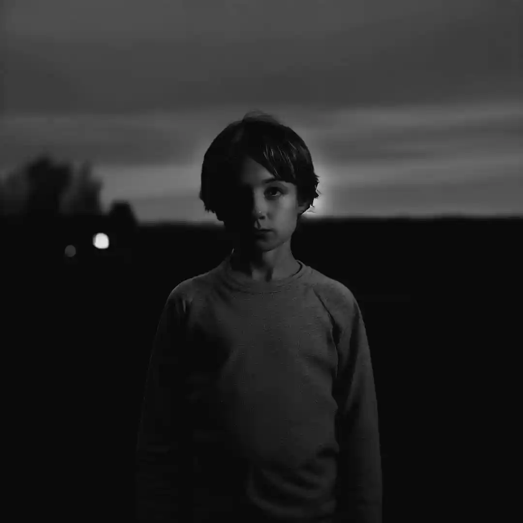 A sad-looking boy in the twilight