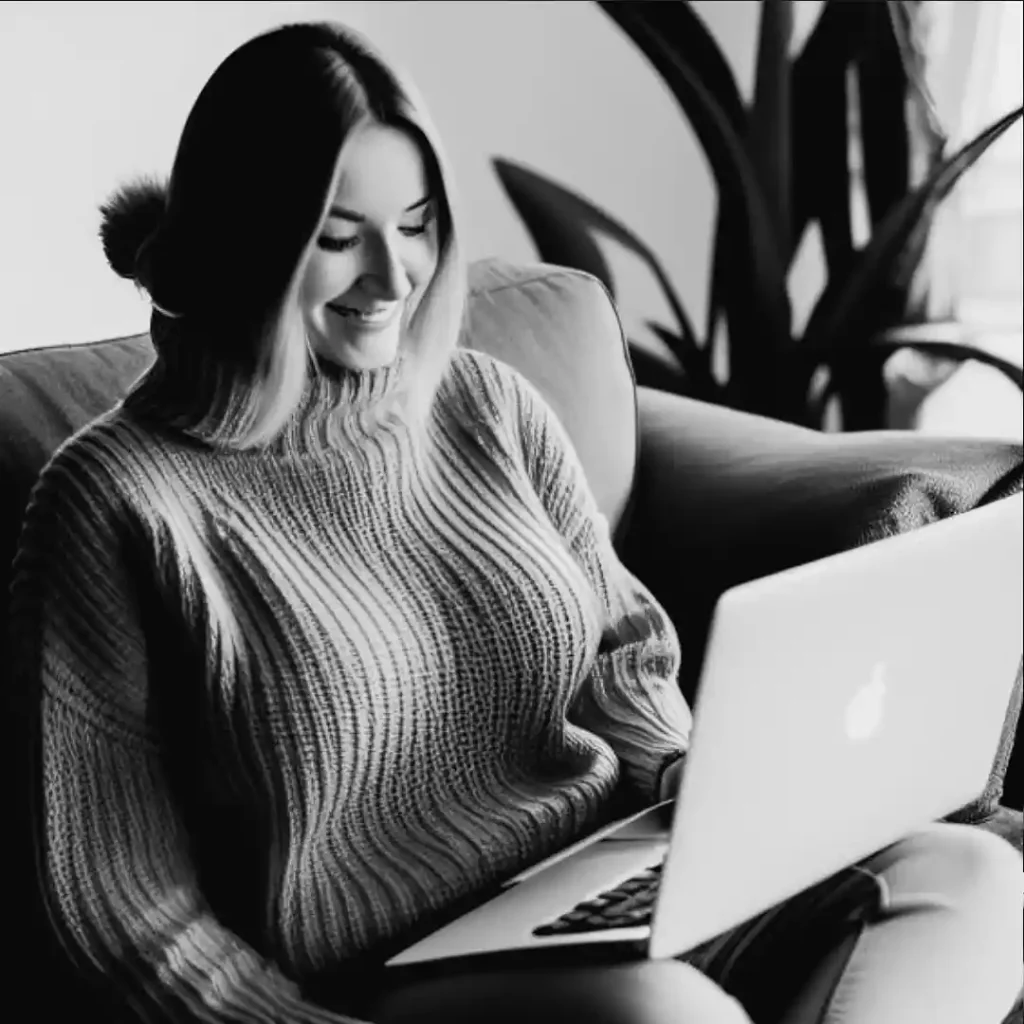 A smiling woman using her laptop