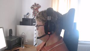 Måns sitter med headset vid datorn och leder en av SMYF samtalsträffar.