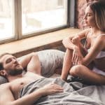 Vakkert par i sengen utøver seksuell kommunikasjon