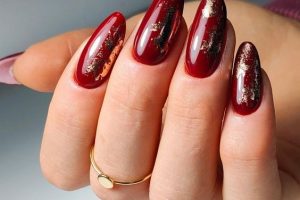 röda naglar med guld glitter marmor