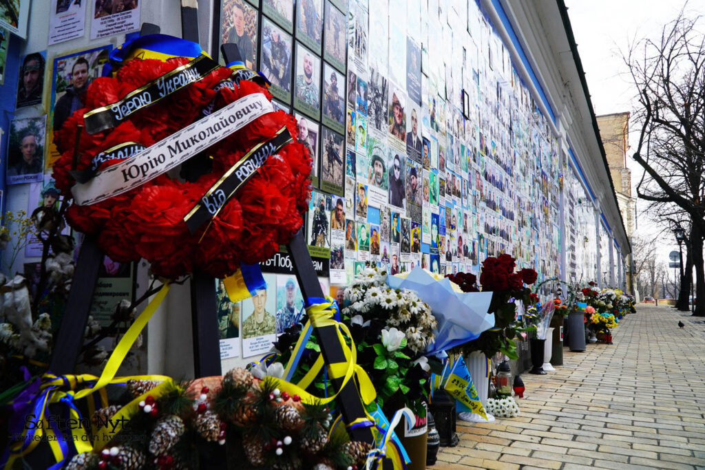 Foran St. Michaels Kirken i Kyiv hænger billeder af faldne soldater på muren. De sørgende lægger blomster - Søften Nyt - Foto: Stefan Weichert.