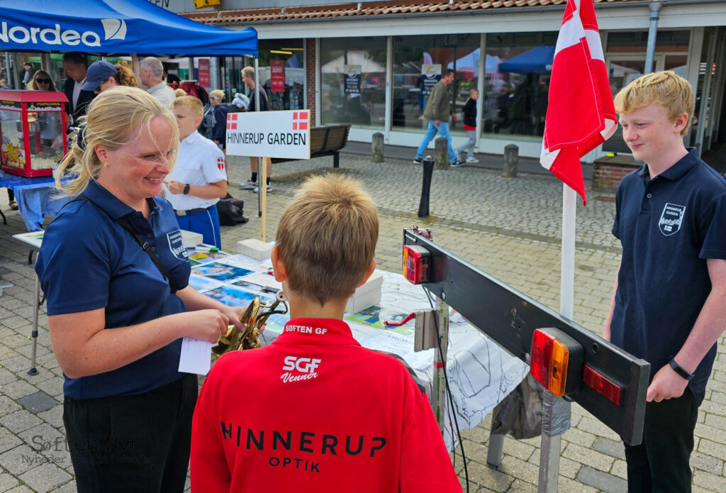 Som frivillig skal Christina Jørgensen hjælpe de mange interesserede, når de kom forbi Hinnerup Gardens stand til byfesten, her er det trompeten, som en ung dreng gerne vil prøve, og bagefter var det en tromme, der blev prøvet af. Foto: Anders Godtfred-Rasmussen - Søften Nyt.