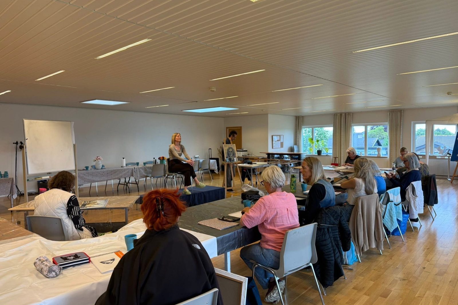 Kursus med levende model. Deltagerne sidder i en halvcirkel om modellen