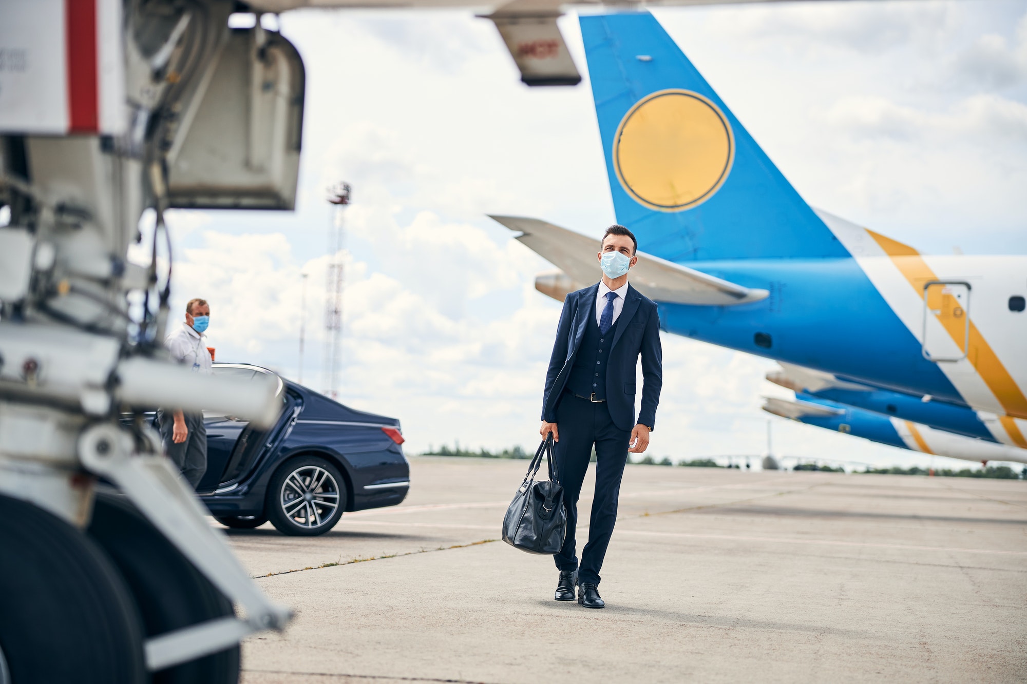 Modern businessman travelling safely with a mask on