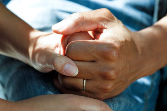 national-cancer-institute-BxXgTQEw1M4-unsplash Närbild på två händer som håller hand.