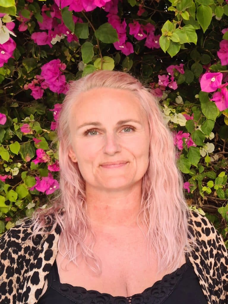 Michelle Andreassen med blomster i baggrunden