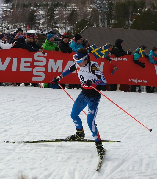 Finske Kerttu Niskanen passerer like bak, men kniper fjerdeplassen i mål på Lugnet skistadion, som skimtes i bakgrunnen lenger nede.