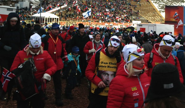 Det skjer mye på Lugnet Skistadion. Her er Petter Northug Fan club på vei ut fra langrennsområdet, mens det gjøres klart for hopprenn.