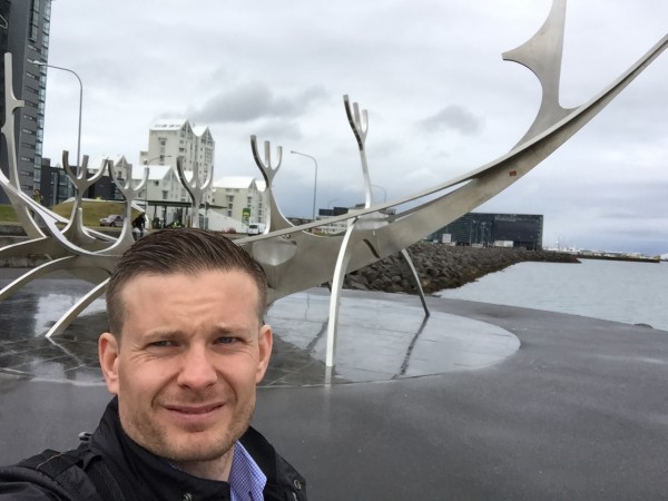 Skulpturen Sun Voyager ligger helt nede ved sjøen. Kunstverket er laget av Jon Gunnar Arnason og er en gigantisk drømmebåt i rustfritt stål som hyller solen. Skipet skal symbolisere lys og håp – akkurat hva mannen på bildet kan behøve før Lidingöloppet utenfor Stockholm om 5 uker! I bakgrunnen til høyre skimter man forøvrig Reykjavik’s stolthet og kjente landemerke, det majestetiske konserthuset Harpa.