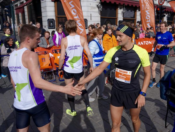 Fornøyde lagkamerater fra Kristiansand Løpeklubb med Andreas Mathingsdal Pedersen til høyre, gratulerer hverandre med innsatsen. Han løp på 33.38 og ble nr. 61. Foto: Thomas Stordalen / Sportsmanden.no 