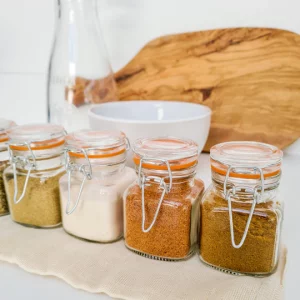 Four small glass jars of spices