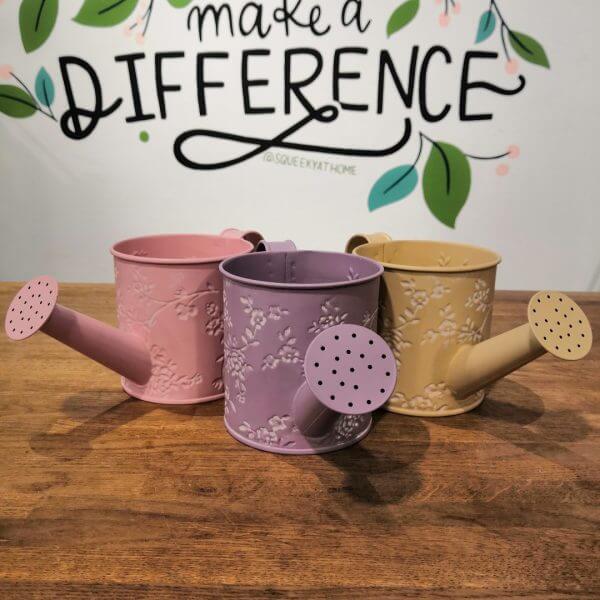 Pink, lavender and yellow floral watering can planters